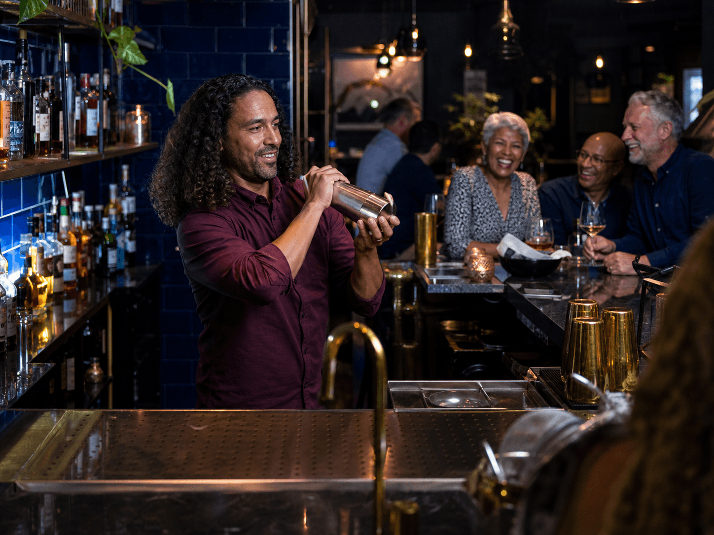 Bartender preparing a drink behind a busy bar